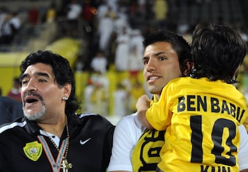 El entrenador argentino del club Al-Wasl, Diego Maradona  se encuentra con su yerno, Sergio Agüero (C), del Manchester City, y su nieto Benjamin al final de un partido de fútbol de la Liga de Campeones en 2012