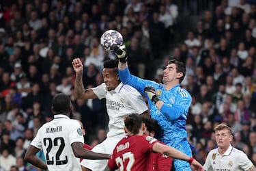 Éder Militão se juega el físico ante el despeje de puños de Thibaut Courtois.