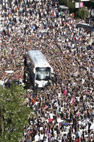 El autobús con los jugadores del Real Madrid llega al estadio Santiago Bernabéu rodeado de aficionados.