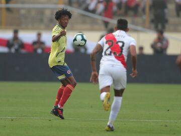 Juan Cuadrado (i) de Colombia disputa un balón con Christofer Gonzales de Perú este domingo en el estadio Monumental U de Lima (Perú). Perú y Colombia se preparan para competir en la Copa América Brasil 2019 a partir del 14 de junio. 