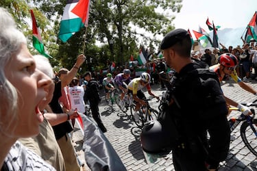 El grupo avanza mientras manifestantes pro-palestinos sostienen banderas palestinas durante la 20ª etapa de la Vuelta a España 2025.