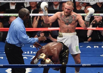 Floyd Mayweather Jr. reacts to a punch from Conor McGregor during their super welterweight boxing match