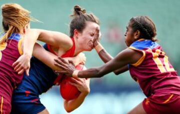 La jugadora de Melbourne Daisy Pearce es defendida por Emily Bates y Delma Gisu durante el partido de rugby femenino Melbourne Demons- Brisbane Lions.