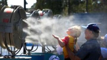 Un hombre y una niña se refrescan debido al calor durante el Abierto de tenis de Australia.