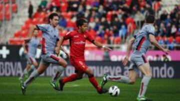 Giovani dos Santos controla el bal&oacute;n ante los jugadores de Osasuna durante el partido en el Iberostar de Mallorca.  