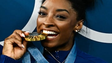 US' Simone Biles poses with her gold medal and a goat necklace after the podium ceremony for the artistic gymnastics women's all around final of the Paris 2024 Olympic Games at the Bercy Arena in Paris, on August 1, 2024. (Photo by Loic VENANCE / AFP)