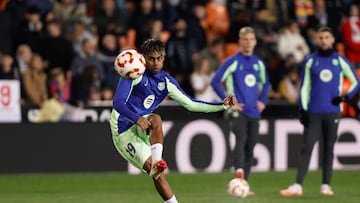 Lamine Yamal golpea el balón en un calentamiento de un partido con el Barça.