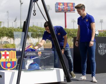 Dos jugadores del Barça B y el equipo femenino depositando la camiseta de Johan Cruyff.
