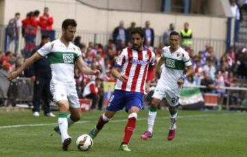 El centrocampista del Atlético de Madrid Raúl García con el balón ante los jugdores del Elche