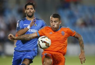 El defensa argentino del Valencia, Nicolás Otamendi controla el balón seguido por el delantero del Getafe Angel Lafita.