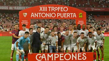 La plantilla del Sevilla posa con el trofeo.