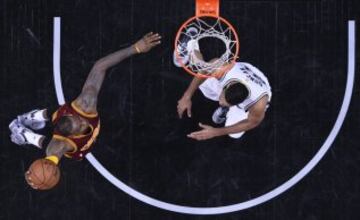 LeBron James trata de encestar ante la mirada de Tim Duncan.