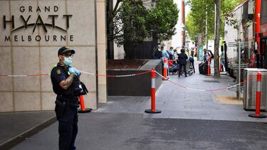 (FILES) In this file photo taken on January 15, 2021 shows an law enforcement officer standing guard outside the Grand Hyatt hotel as tennis players and officials arrive for a two-week quarantine period ahead of the Australian Open tennis tournament, in M
