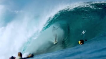 Un surfista surfeando en la ola de Teahupoo (Tahit&iacute;, Polinesia Francesa) con varia gente (surfistas y fot&oacute;grafos) mirando. 