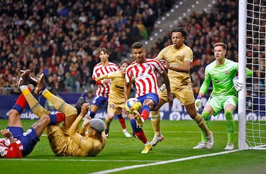 Reinildo Mandaba controla la pelota de espaldas a la portería de Marc-André ter Stegen. Jules Koundé, atento a la acción del lateral rojiblanco.