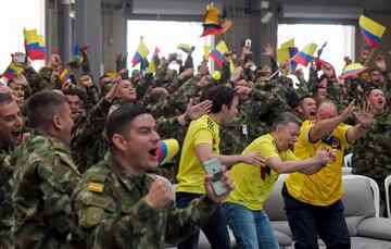 El presidente colombiano Juan Manuel Santos y su hijo Esteban celebran el gol de Yerry Mina junto con el ejército de Colombia en una base militar en Tolemaida, Colombia.
