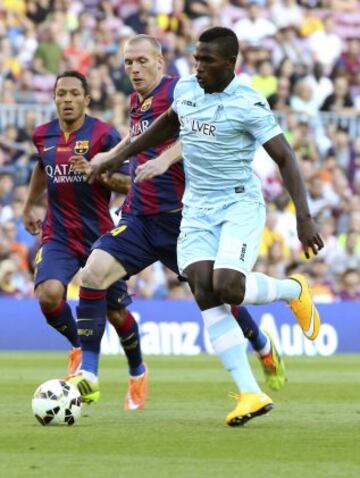 El delantero nigeriano del Granada, Isaac Success, disputa el balón el defensa francés del Barcelona, Jeremy Mathieu.
