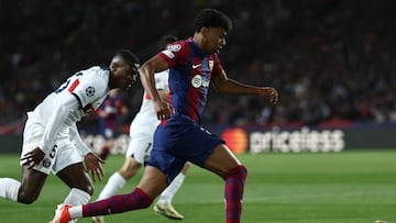 Paris Saint-Germain's Portuguese defender #25 Nuno Mendes fights for the ball with Barcelona's Spanish forward #27 Lamine Yamal during the UEFA Champions League quarter-final second leg football match between FC Barcelona and Paris SG at the Estadi Olimpic Lluis Companys in Barcelona on April 16, 2024. (Photo by FRANCK FIFE / AFP)