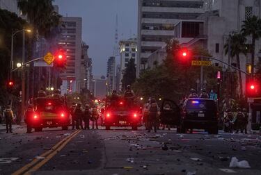 Agentes del Sheriff del Condado de Los Ángeles vigilan a los manifestantes en una calle cubierta de municiones "menos letales" usadas, durante una protesta contra las redadas federales de inmigración en el centro de Los Ángeles.