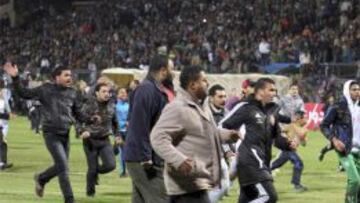 Aficionados agipcios huyendo de la tragedia en Port Said en el partido entre el equipo local Al Masry y el cairota Al Ahly.