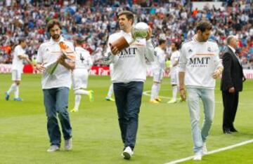 Sergio Llull, Felipe Reyes y Rudy Fernández, en el Santiago Bernabéu con los títulos de la Supercopa y la Liga.