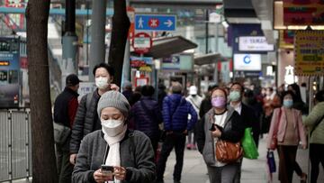 Pedestrians wearing face masks following the coronavirus disease (COVID-19) outbreak walk on a street at Causeway Bay district in Hong Kong, China February 9, 2022. REUTERS/Joyce Zhou