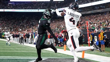 Oct 31, 2024; East Rutherford, New Jersey, USA; New York Jets wide receiver Garrett Wilson (5) catches a touchdown pass while being defended by Houston Texans cornerback Kamari Lassiter (4) during the second half at MetLife Stadium. Mandatory Credit: Ed Mulholland-Imagn Images TPX IMAGES OF THE DAY