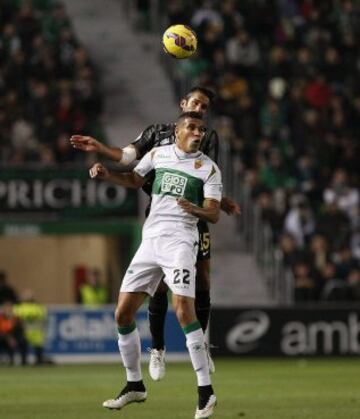 El defensa argentino del Málaga Marcos Angeleri (detrás) lucha un balón con el delantero brasileño del Elche Jonathas de Jesus, durante el partido de la decimosexta jornada de Liga de Primera División 