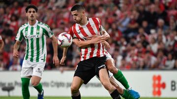 Athletic Bilbao's Spanish midfielder #08 Oihan Sancet (front) is grabbed by Real Betis' Spanish midfielder #16 Sergi Altimira during the Spanish league football match between Athletic Club Bilbao and Real Betis at the San Mames stadium in Bilbao on November 3, 2024. (Photo by ANDER GILLENEA / AFP)
