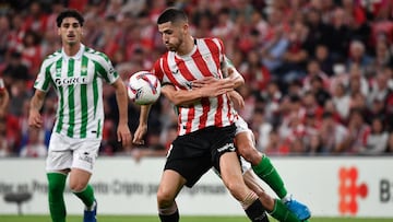Athletic Bilbao's Spanish midfielder #08 Oihan Sancet (front) is grabbed by Real Betis' Spanish midfielder #16 Sergi Altimira during the Spanish league football match between Athletic Club Bilbao and Real Betis at the San Mames stadium in Bilbao on November 3, 2024. (Photo by ANDER GILLENEA / AFP)