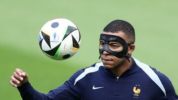 France's forward #10 Kylian Mbappe, wearing a protective mask, eyes the ball during a training session  training session at the Home Deluxe Arena Stadium in Paderborn, western Germany, on June 23, 2024, during of the UEFA Euro 2024 football championship. (Photo by FRANCK FIFE / AFP)