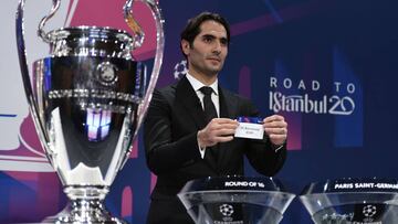 UEFA Champions League's ambassador Hamit Altintop holds the slip of FC Barcelona during the UEFA Champions League football cup round of 16 draw ceremony on December 16, 2019 in Nyon. (Photo by Fabrice COFFRINI / AFP)