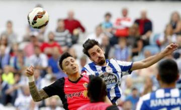 El centrocampista del Deportivo de La Coruña Isaac Cuenca (d) lucha un balón con el defensa de la UD Almería Ximo Navarro (i), durante el partido de la sexta jornada de Liga de Primera División, disputado esta tarde en el estadio de Riazor.