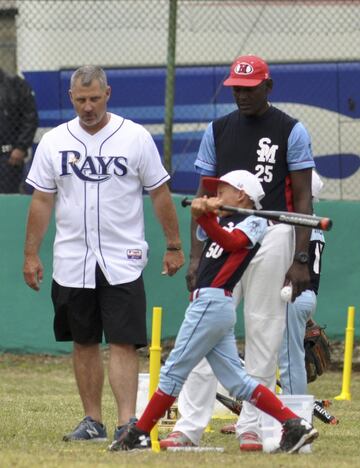 El coach de bateo de los Tampa Bay Rays, Derek Shelton y el jugador retirado cubano Michel Ford participan en un clínica de baseball para niños en Cuba.