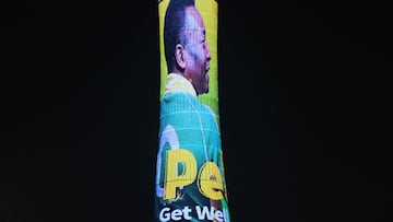 A picture taken on December 3, 2022, in Doha, during the Qatar 2022 World Cup football tournament, shows the Torch tower of Doha also known as the Aspire Tower, lit by a screen depicting Brazilian star Pele and reading a message in support to the former Brazilian football player who is being treated for a "respiratory infection" at the hospital in Sao Paulo. - Brazilian football legend Pele, who was hospitalized this week amid ongoing cancer treatments, has developed a respiratory infection, but is in stable condition and "showing general improvement," his doctors said Friday, December 2. (Photo by NELSON ALMEIDA / AFP)