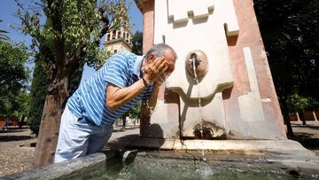 Un hombre se refresca en una fuente para aliviar las altas temperaturas en Córdoba.