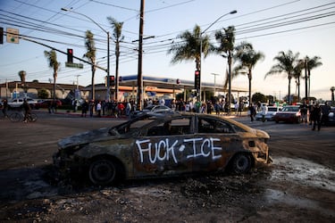 Un automóvil quemado, con un insulto al ICE escrito en aerosol, reposa en una calle en Paramount, California. Debido a que la situación se elevó en cuanto a violencia, Donald Trump anunció el envío de 2,000 agentes de la Guardia Nacional, pese a que ni la alcaldesa de Los Ángeles, Karen Bass, ni el gobernador de California, Gavin Newsom, solicitaron la intervención. Ello llevo a la administración de Newsom a presentar una demanda contra el gobierno de Trump, por exceder su autoridad.