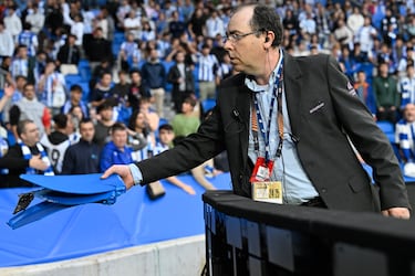 Un empleado de seguridad del club de San Sebastián retira los asientos lanzados desde la zona donde se encontraban los ultras del equipo belga.