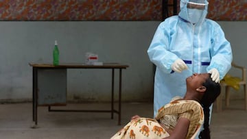 A health worker wearing Personal Protective Equipment (PPE) gear collects a swab sample of a pregnant woman at a free COVID-19 coronavirus testing centre at Medchal Malkajgiri district on the outskirts of Hyderabad on August 24, 2020. - India's confi