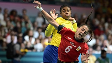 Spain's centre back #06 Carmen Campos (R) attempts to score during the Women's Preliminary Round Group B handball match between Spain and Brazil of the Paris 2024 Olympic Games, at the Paris South Arena in Paris, on July 25, 2024. (Photo by Aris MESSINIS / AFP)