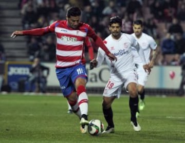 El delantero del Granada Iván Sanchez-Rico "Riki" (i) disputa un balón con el centrocampista argentino del Sevilla Éver Banega (d), durante el partido de octavos de final de la Copa del Rey que se juega hoy en el estadio Los Cármenes, de Granada.