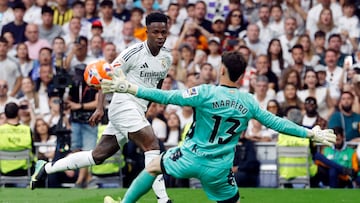 Real Madrid's Brazilian forward #07 Vinicius Junior and Real Sociedad's Spanish goalkeeper #13 Unai Marrero vie for the ball during the Spanish league football match between Real Madrid CF and Real Sociedad at Santiago Bernabeu Stadium in Madrid on May 24, 2025. (Photo by Pierre-Philippe MARCOU / AFP)