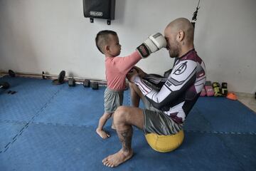 El luchador colombiano de artes marciales mixtas JC Fernández entrena en casa con su hijo Maxi durante el aislamiento obligatorio decretado por el gobierno para detener la propagación del COVID-19 el 5 de mayo de 2020 en Cali, Colombia.