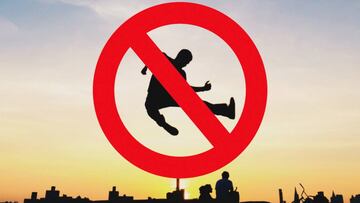 La silueta de un chico que practica parkour ante la pueta de sol, con los edificios de una ciudad al fondo. Con el símbolo de prohibido encima.