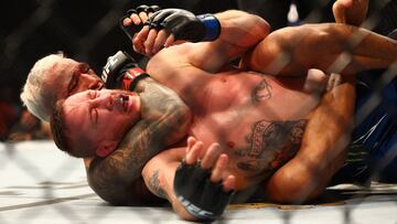 Charles Oliveira somete a Justin Gaethje durante el UFC 274.