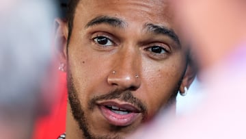 Mercedes' British driver Lewis Hamilton speaks with people in the paddock at the Bahrain International Circuit in Sakhir ahead of the Bahrain Formula One Grand Prix on March 2, 2023. (Photo by Giuseppe CACACE / AFP)