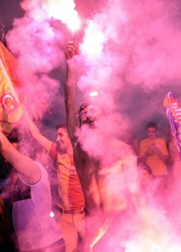 Fanáticos del equipo Galatasaray celebran, la Superliga de Campeones de Turquía, en Estambul (Turquía). El Galatasaray logró su vigésimo título de campeón de la Liga turca, tras el empate (2-2) cosechado hoy por el Fenerbahce, segundo clasificado, en su visita al campo del Istanbul Basaksehir. 