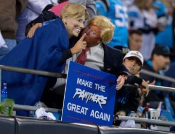 Donald Trump sigue liandola en campa?a. Aqu¨ª con un cartel de "Haced a los Panthers grandes otra vez". El gobernador de Carolina (de arriba o de abajo, no lo s¨¦) ya ha retirado su apoyo al candidato republicano y le ha acusado de gafar al equipo. Adem¨¢s, la Hillary con la que posa es falsa, que hemos notado que lleva una careta de poliesp¨¢n.