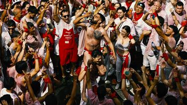 Un asistente al "Chipinazo" bebe vino de su propia zapatilla durante las fiestas que marcan el inicio oficial de las Fiestas de San Fermín en la Plaza Consistorial, frente al Ayuntamiento de Pamplona.