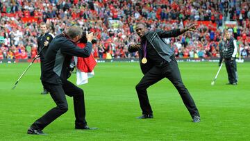 Usain Bolt hace su famoso gesto sobre el c&eacute;sped de Old Trafford tras ser homenajeado por la afici&oacute;n del Manchester United tras ganar el oro de 100 metros lisos en los Juegos Ol&iacute;mpicos de Londres.